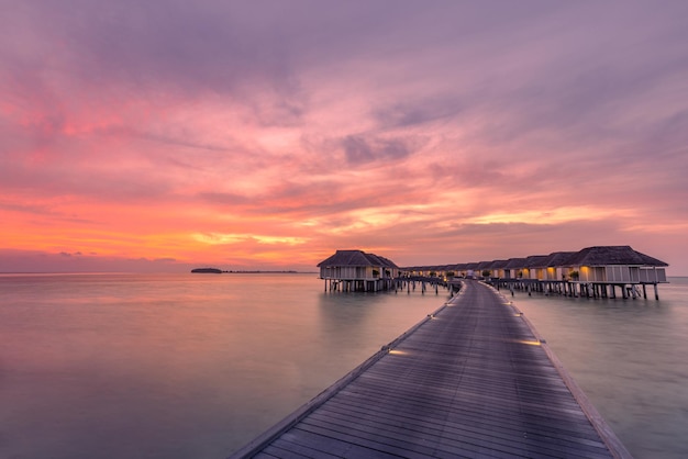 Fantastisch zonsonderganglandschap op de Malediven. Verbazingwekkende wolken en kleurrijke hemelwatervilla's, bungalows