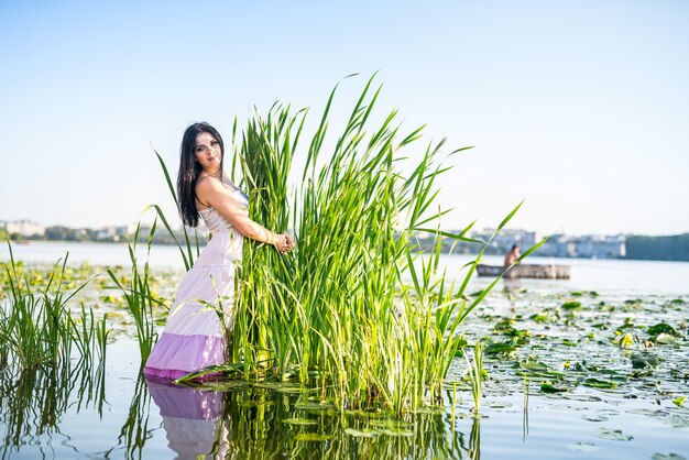 Fantastische mooie vrouw stond in de buurt van zegges in water