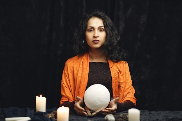 Fantasy beautiful gypsy girl. Fortune teller woman reading future on magical tarot cards.