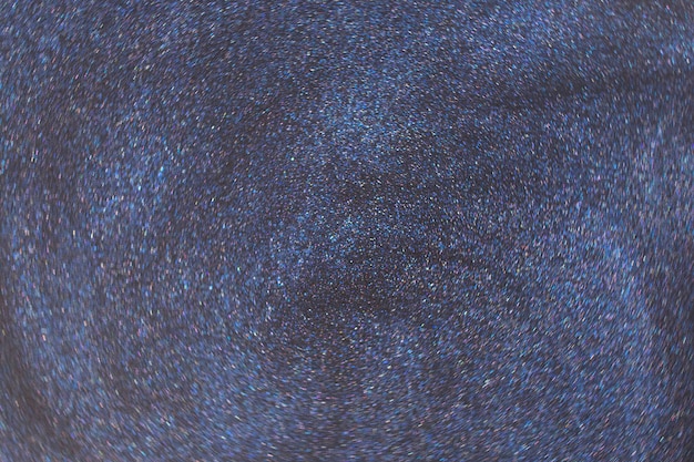 Fantasy bokeh glitter dust on dark magic background.