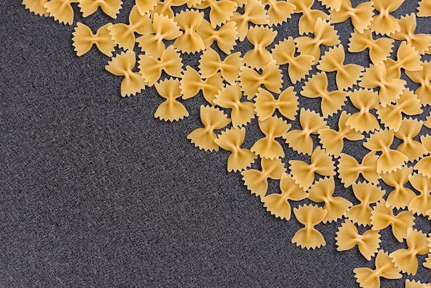 Макаронные изделия Farfalle или бабочки на черной предпосылке. Кук фон. Итальянская кухня. Копировать пространство Шаблон. Макет