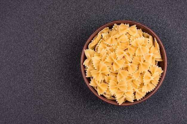 Farfalle or Bow Tie Pasta in bowl on gray background Italian pasta Copy space