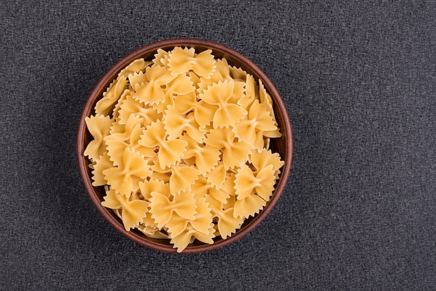 Farfalle or Bow Tie Pasta in bowl on gray space. Italian pasta