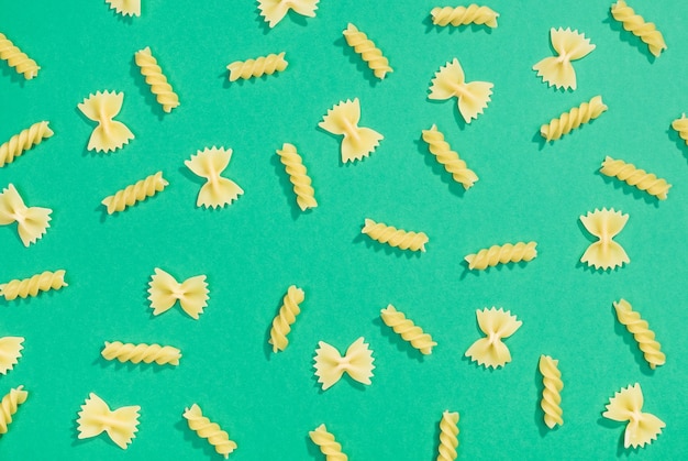 Farfalle en fusilli pasta willekeurig plat lag patroon op groene achtergrond