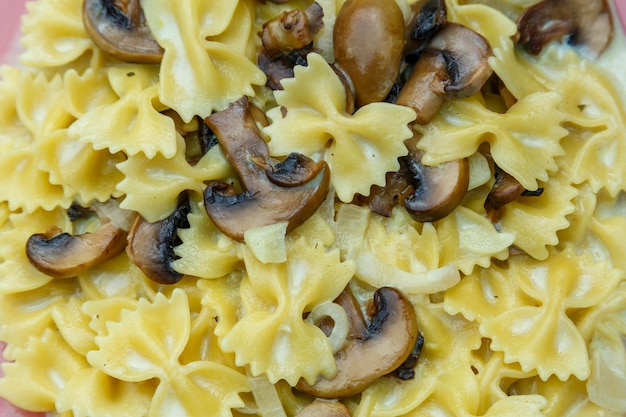 Farfalle pasta in een romige saus met champignons close-up