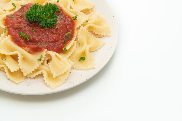 Farfalle pasta in tomatensaus met peterselie geïsoleerd op witte achtergrond