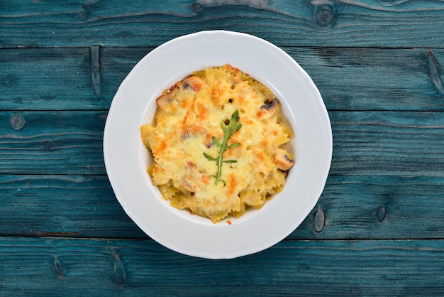 Farfalle pasta met kaas en champignons Op een houten ondergrond Bovenaanzicht Kopieer de ruimte