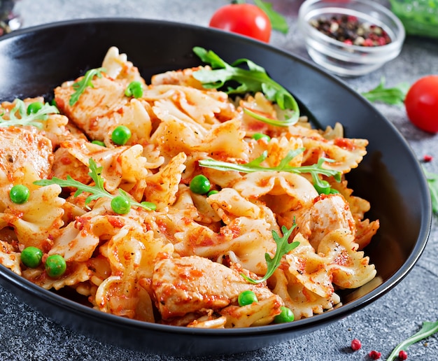 Farfalle pasta met kipfilet, tomatensaus en groene erwten. Italiaanse maaltijd. Voedsel menu