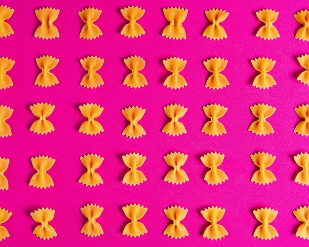 Foto farfalle pasta su uno sfondo rosa