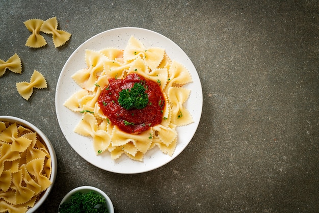 Photo farfalle pasta in tomato sauce with parsley - italian food style