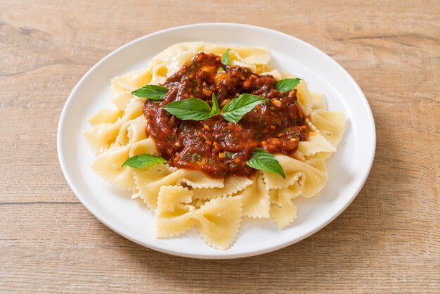 Farfalle di pasta con basilico e aglio in salsa di pomodoro - salsa italiana