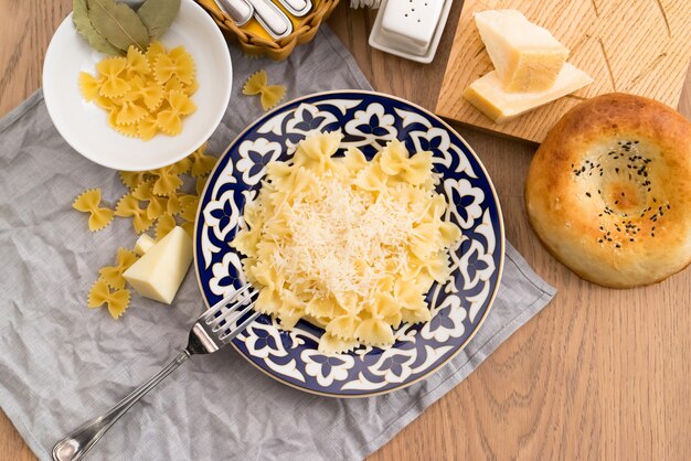 Farfalle pasta with cheese in a plate with a traditional Uzbek 