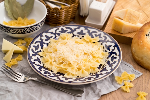 Farfalle pasta with cheese in a plate with a traditional Uzbek 