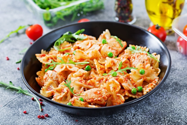 치킨 필레, 토마토 소스 및 완두콩과 Farfalle 파스타. 이탈리아 식사. 음식 메뉴