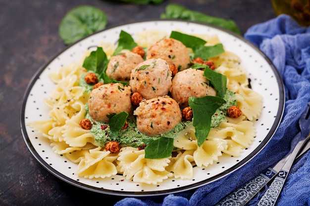 Farfalle pasta with meatballs and spinach sauce with fried chickpeas. 