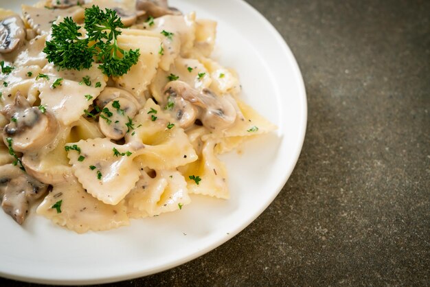 Foto pasta farfalle con salsa di crema bianca ai funghi