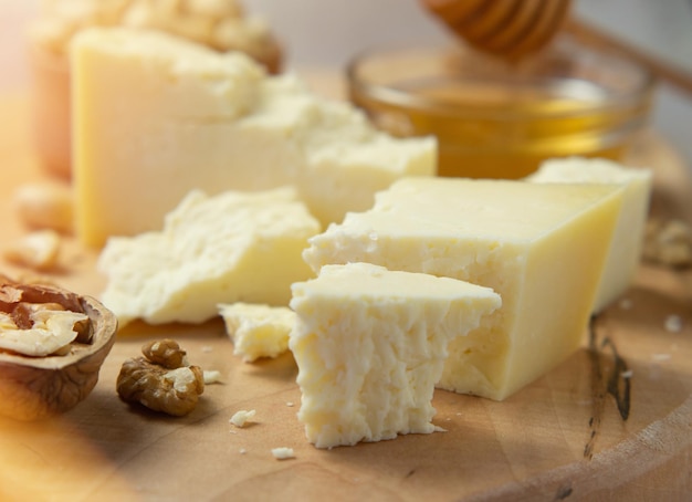 Farm cheese served with honey and nuts on a light texture background. Copy space