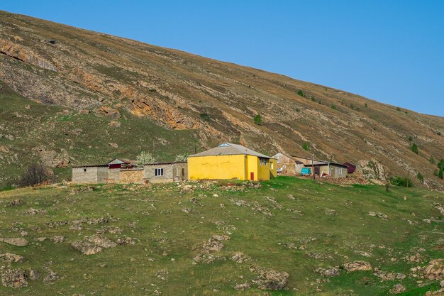 山の中の農場。山の中の黄色い石造りの家。観光客やハイカーのためのキャンプ。旅行と不動産の概念。