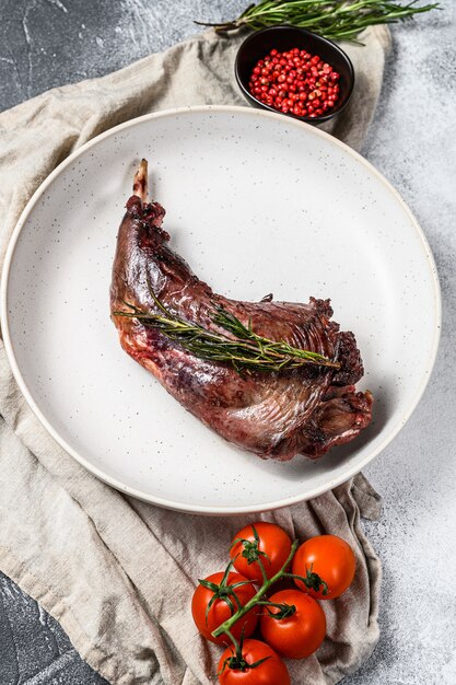 Farm rabbit leg stew served with fresh tomatoes and rosemary.Top view