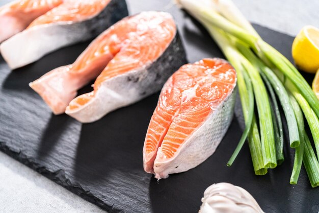 Farm-raised salmon steaks on a slate board.