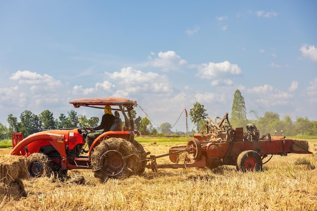 On a farm in Ratchaburi Thailand farmers use agricultural machine to compress and bundle rice straw