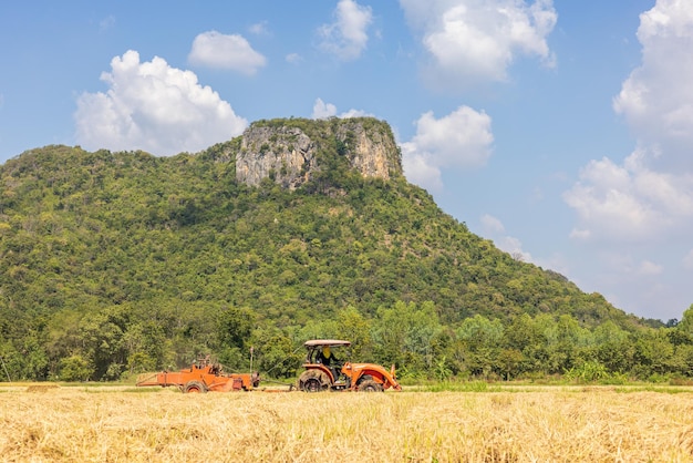 On a farm in Ratchaburi Thailand farmers use agricultural machine to compress and bundle rice straw