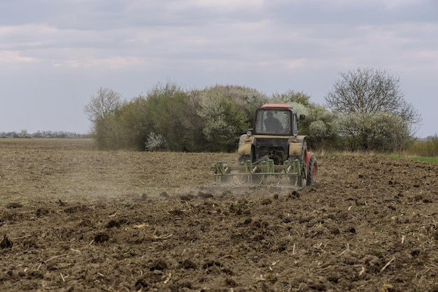 農地で土壌を粉砕する農業用トラクター