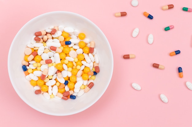 Farmaceutische industrie en geneesmiddelen gekleurde pillen in witte schaal