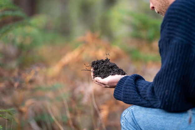 Farmer in agriculture looking at a soil sample on a farm x9