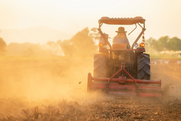 Contadino sul grande trattore nella terra per preparare il terreno