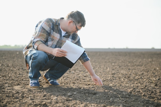 A farmer checks quality of soil before sowing