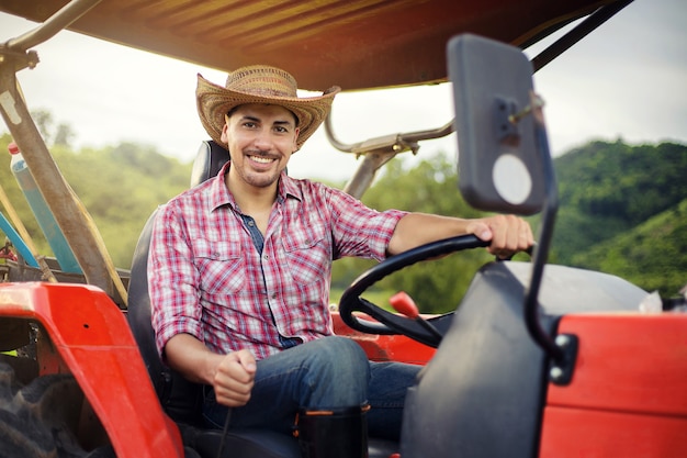 Фермер водит трактор на полях во время сбора урожая в сельской местности.
