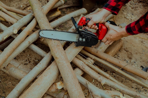 A farmer is using a chain saw to cut firewood