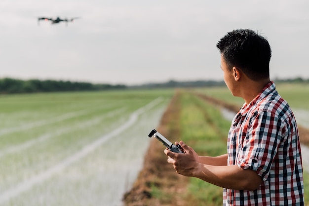 фермер управляет дроном над сельскохозяйственными угодьями. Высокотехнологичные инновации для повышения производительности в сельском хозяйстве