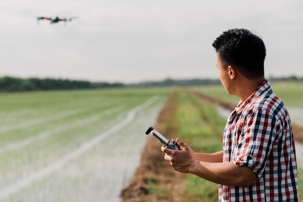 farmer navigating drone above farmland. High technology innovations for increasing productivity in agriculture