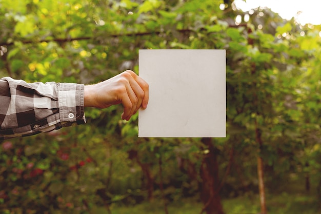 Farmer's hands holding a square white empty frame