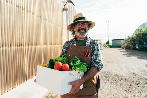 Photo farmer senior man working in his farm and greenhouse