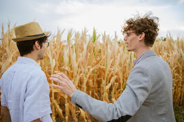 L'agricoltore mostra all'assicuratore i danni causati dalla siccità al suo campo di mais concetto di siccità