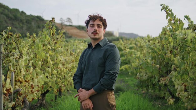 Farmer standing grape plantation with yellow grapevine close up worker posing