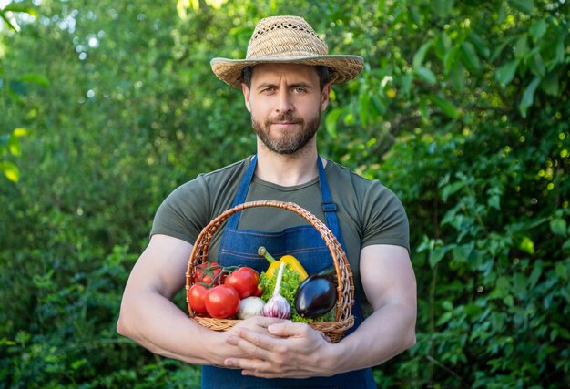 Photo farmer in straw hat hold basket full of vegetables