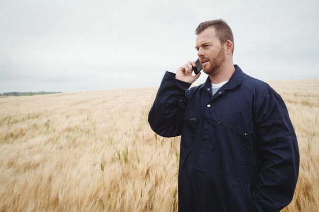 Farmer talking on mobile phone in the field