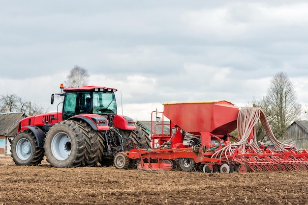 Фермерский трактор работает в поле Весеннее время для посева Посадка сельскохозяйственных культур