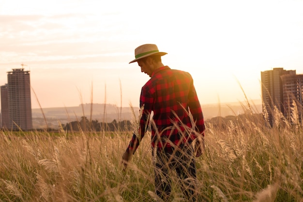 Farmer with hat in farm plantation on sunset. 