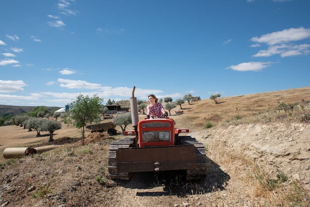 Farmer woman driving a tractor in the field