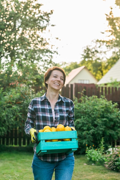 Farmer woman holding wooden box full of fresh raw vegetables copy space and empty place for text bas