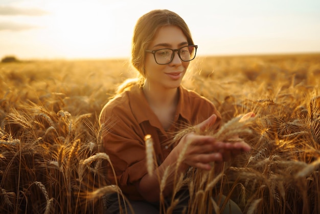 Женщина-фермер на пшеничном поле проверяет урожай Сбор урожая в саду или концепция экологии Умное сельское хозяйство
