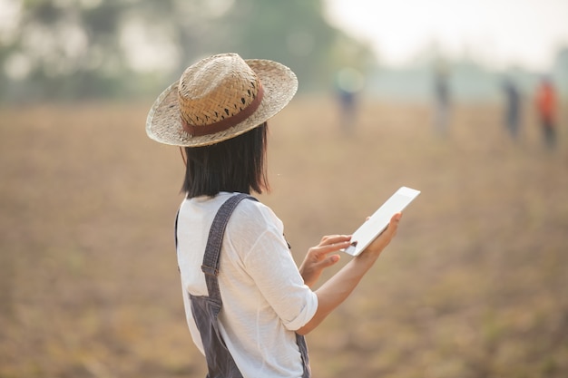 Фермер, работающий на поле с помощью планшета в современном сельском хозяйстве.