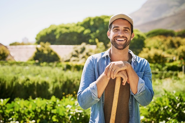 Foto vanga agricola e ritratto di uomo o contadino in agricoltura giardino sostenibile o piccolo imprenditore in campo terreno agricolo e volto di persona felice con piante eco-compatibili e agrosostenibilità