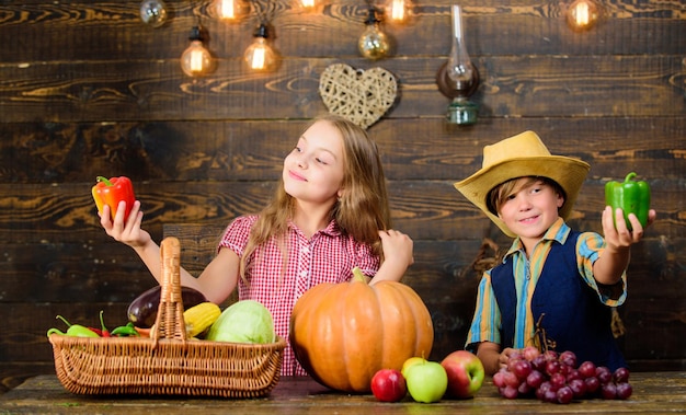 Farming teaches kids where their food comes from Family farm Siblings having fun Children presenting farm harvest wooden background Farm market Kids farmers girl boy vegetables harvest