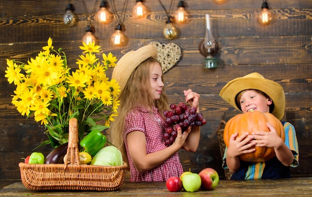 Farming teaches kids where their food comes from Siblings having fun Family farm Farm market Children presenting farm harvest wooden background Kids farmers girl boy vegetables harvest